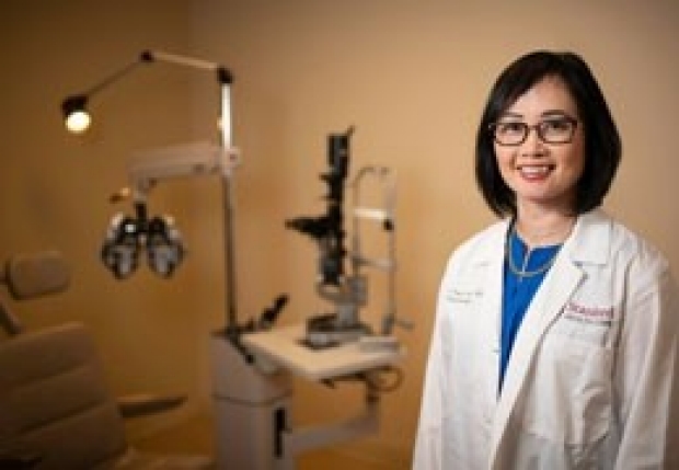 Joyce Liao, director of the Stanford Center for Optic Disc Drusen at the Byers Eye Institute, stands in front of ophthalmic equipment.